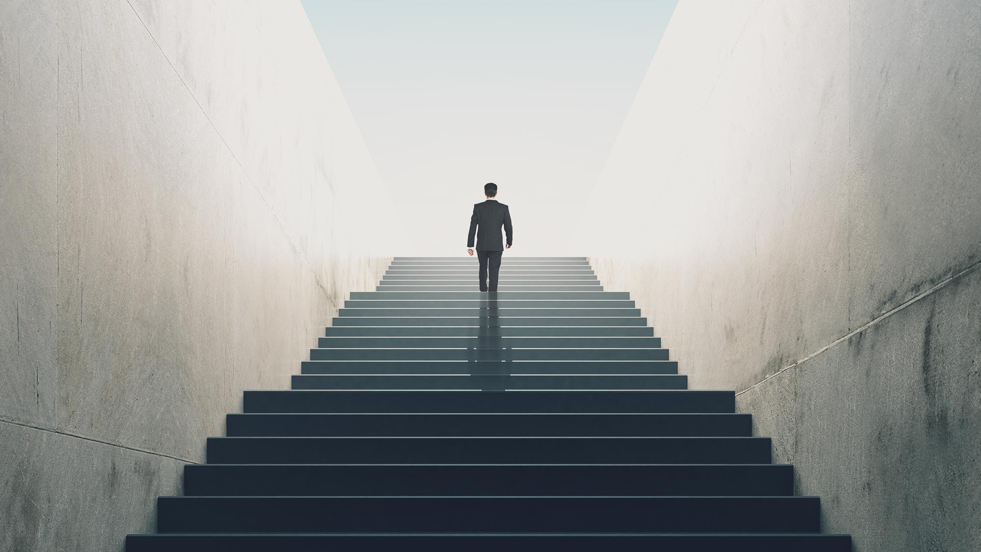 Professional Male In A Dark Suite, Walking Up A Tall Staircase